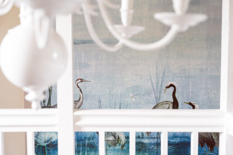 Détail de la tapisserie panoramique bleue avec oiseaux, installée à l’entrée de la suite parentale dans une maison rénovée du Vercors.