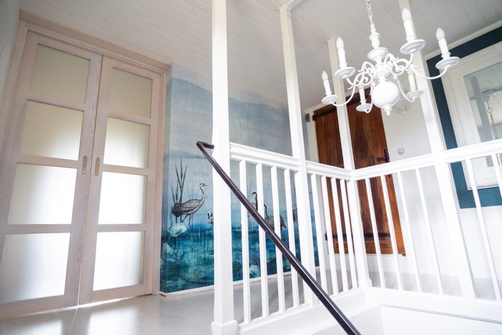 Entrée de la suite parentale avec double porte battante vitrée et tapisserie panoramique dans une maison ancienne rénovée à Saint-Nizier-du-Moucherotte.