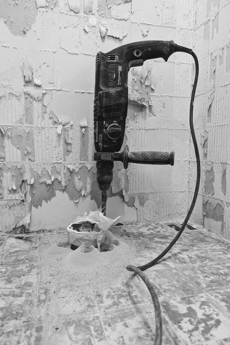 Perceuse sur un mur en cours de rénovation, illustration des erreurs à éviter sur un chantier