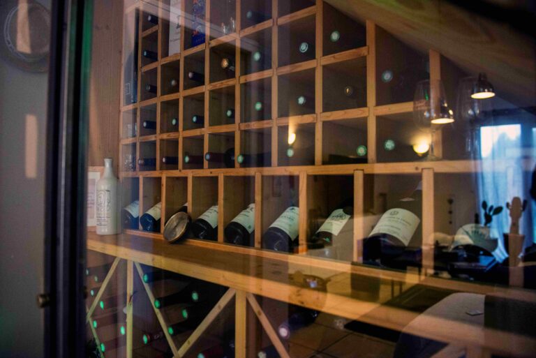 Détail des croisillons en bois clair de la cave à vin sur mesure sous escalier.