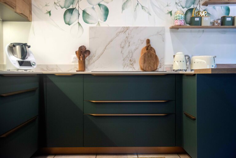 Crédence effet marbre avec façades vert émeraude et électroménager Smeg crème