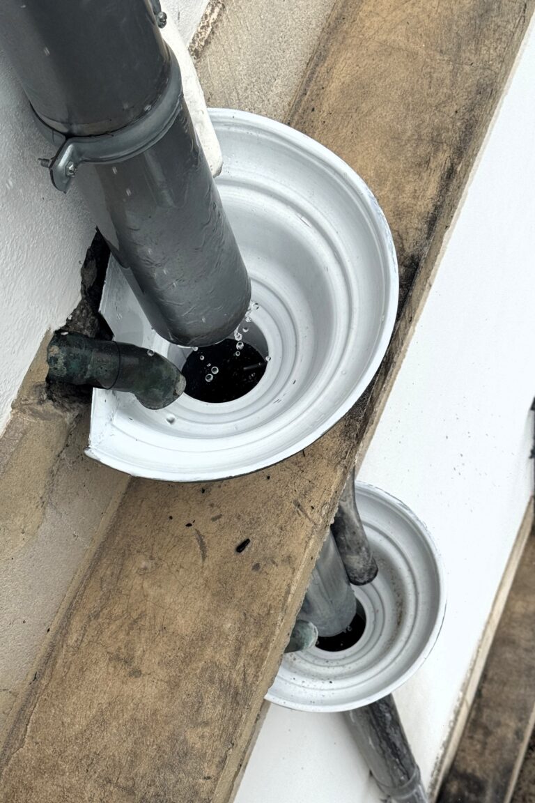 Façade d’un immeuble ancien montrant une évacuation d’eaux usées raccordée de façon improvisée à une descente d’eaux pluviales.