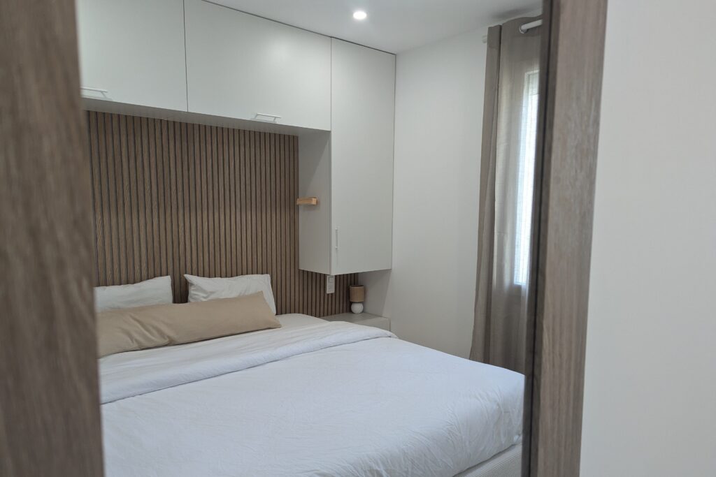 Chambre optimisée avec rangements sur mesure dans un T2 rénové à Varces après amélioration énergétique.