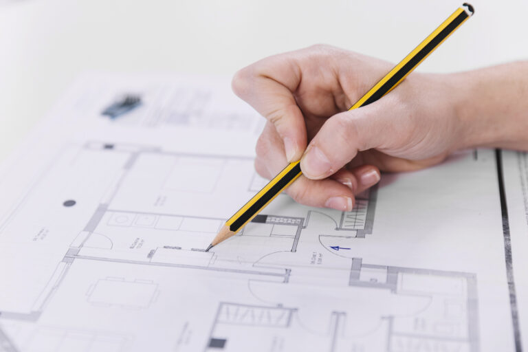 main dessinant un plan d aménagement intérieur pour un projet de rénovation sur papier