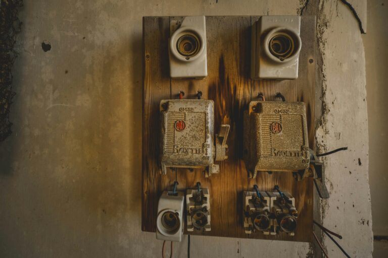 Ancienne installation électrique murale avec fusibles illustrant les contraintes techniques invisibles lors de l’achat d’un bien immobilier