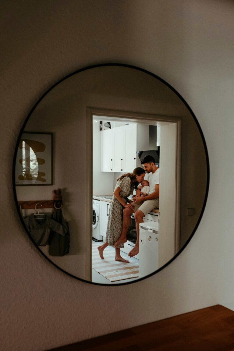 Famille avec un bébé dans une cuisine, reflet dans un miroir illustrant le logement comme espace de vie permanent