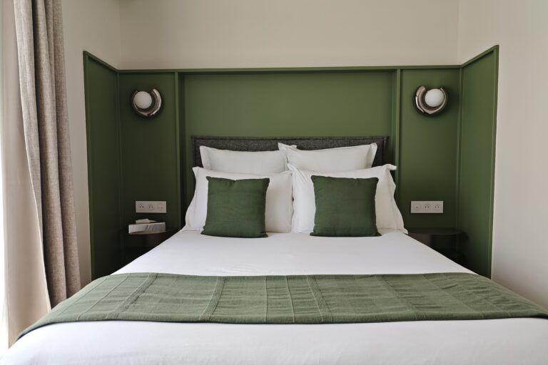 Chambre d’hôtel au Pays basque avec tête de lit sur mesure verte et appliques intégrées
