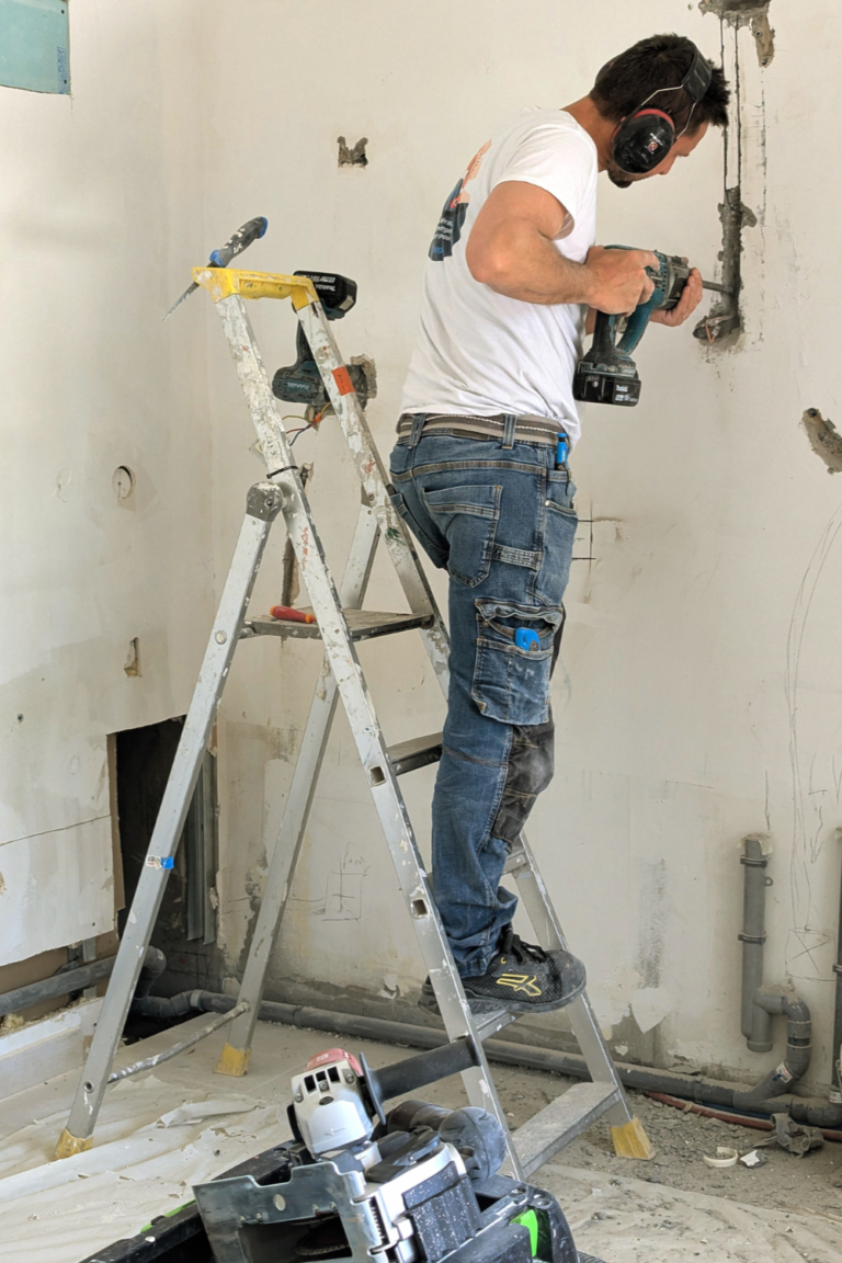 Artisan réalisant les travaux électriques sur un chantier de rénovation